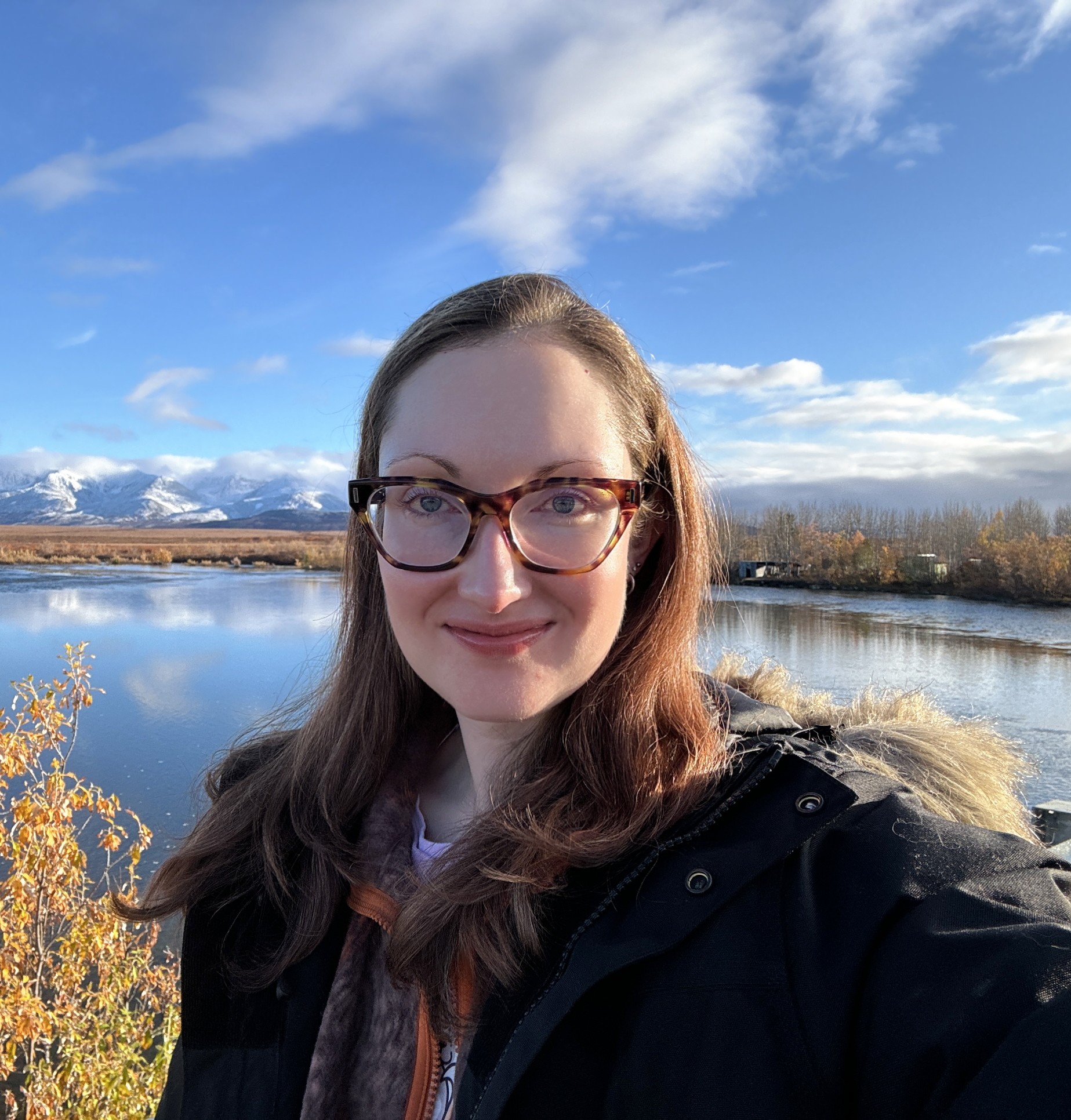 An image of Meghan Drake in front of mountains in Alaska.