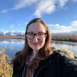 An image of Meghan Drake in front of mountains in Alaska.