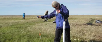 a person standing in a field holding a white object