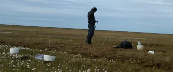 a man standing in a field with a camera