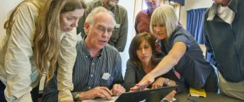 a group of people looking at a laptop