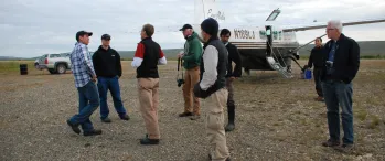 a group of people standing near a small plane