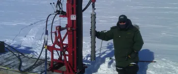 a man standing next to a machine in the snow