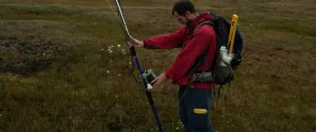 a man in a red jacket holding a measuring device