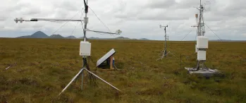 a couple of antennas sitting on top of a lush green field